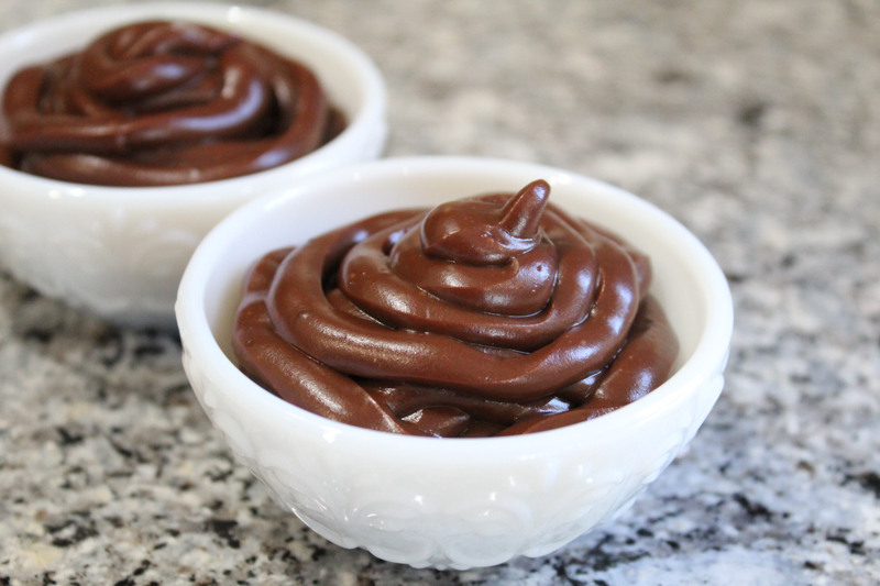 two white bowls with dairy free chocolate pudding on a gray granite countertop