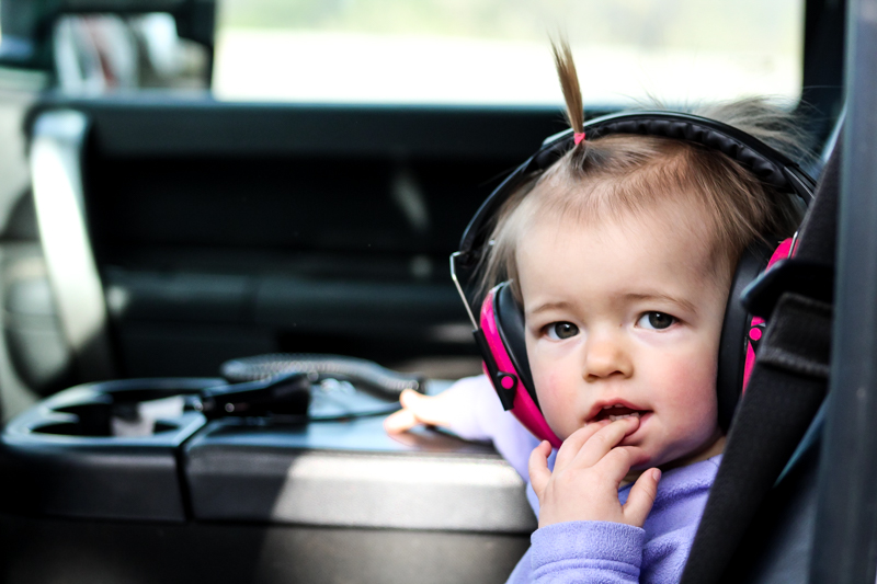 little girl with headphones on chewing on her fingers