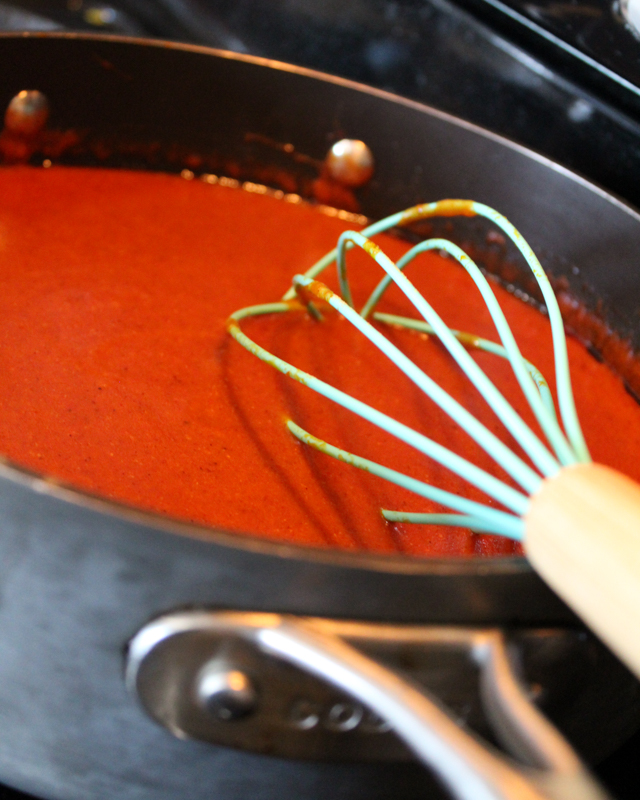 enchilada sauce in a saucepan with a whisk