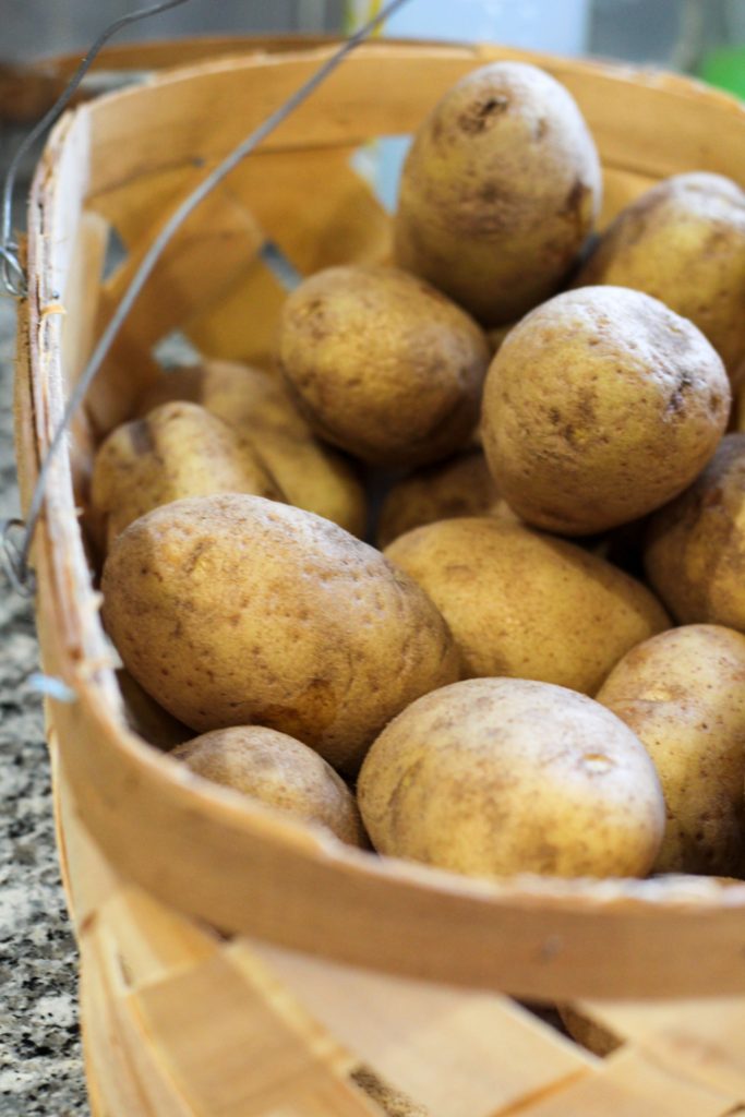 russet potatoes in a woven basket on the countertop