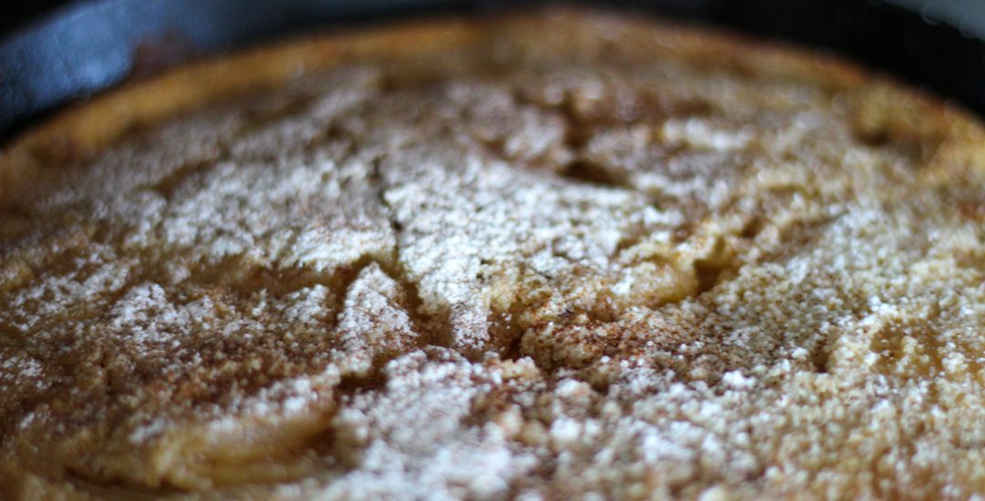 sourdough dutch baby topped with powdered sugar and cinnamon