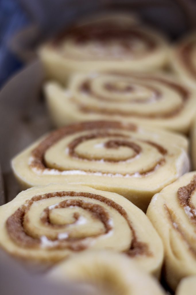 sliced cinnamon rolls in a pan ready to rise