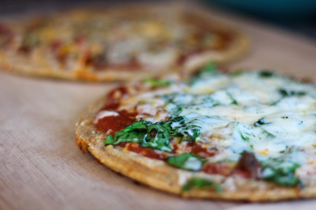homemade pizzas on a wooden cutting board