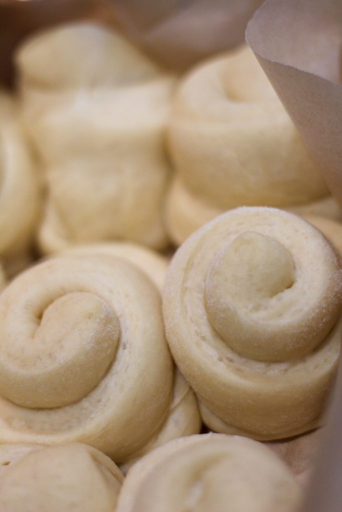 butter rolls in a pan lined with parchment paper after their second rise
