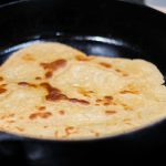 einkorn sourdough tortilla cooking in a cast iron skillet