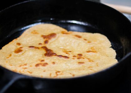 einkorn sourdough tortilla cooking in a cast iron skillet